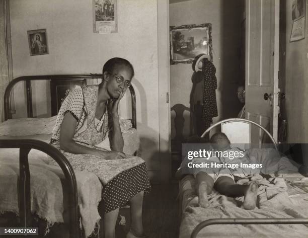 Washington, D.C. Mrs. Ella Watson, who has been a government charwoman for twenty-six years, with three of the five children she supports on her...