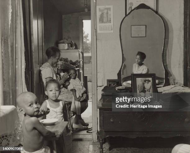 Washington, D.C. Dinner time at the home of Mrs. Ella Watson, a government charwoman. Artist Gordon Parks.