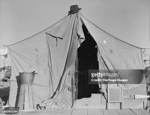 One of a row of tents, home of a pea picker. Near Calipatria, Imperial Valley, California. [Note upturned basket for carrying peas, and washboard]....