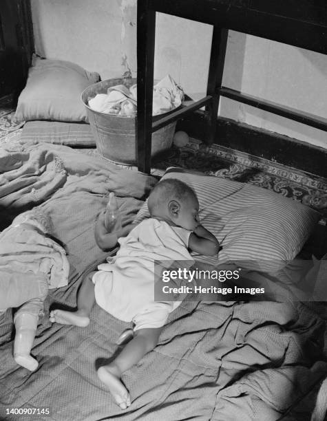 Washington, D.C. Grandchild of Mrs. Ella Watson, a government charwoman, taking her afternoon nap. Artist Gordon Parks.