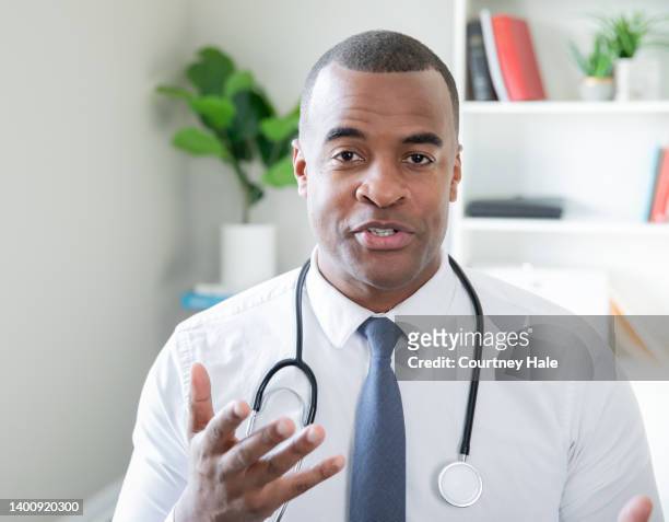 doctor gesturing his hand while he explains treatment - clinic stock pictures, royalty-free photos & images