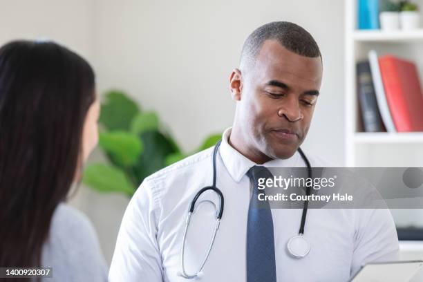 doctor reads test results to patient - gp practice stock pictures, royalty-free photos & images