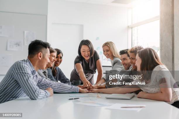 korean mature businesswoman leads multiracial group of work colleagues in team building and agreement positive emotion in brainstorming planning session together in modern office meeting daytime - european best pictures of the day september 12 2015 stockfoto's en -beelden