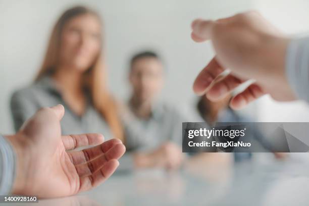 personal perspective view of speaker’s hands gesturing during business meeting at table in office with work colleagues, decisions, women’s rights - human rights hands stock pictures, royalty-free photos & images