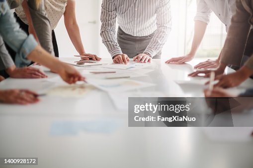 Low-Angle-Ansicht der Hände einer multirassischen Gruppe von Menschen, die mit Ideen arbeiten und gemeinsam brainstormen, um Entscheidungen mit Dokumenten auf dem Tisch in kreativer Büro-Teamarbeit zu treffen Low-Angle-Ansicht der Hände einer multirassischen Gruppe von Menschen, die mit Ideen arbeiten und gemeinsam brainstormen, um Entscheidungen mit Dokumenten auf dem Tisch in kreativer Büro-Teamarbeit zu treffen