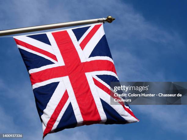 national flag of the united kingdom flutters in the winds on its mast and against a background of blue sky in london - new patriotic party stock pictures, royalty-free photos & images