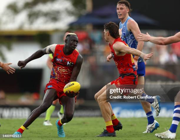 Mabior Chol of the Suns handballs during the round 12 AFL match between the Gold Coast Suns and the North Melbourne Kangaroos at TIO Stadium on June...