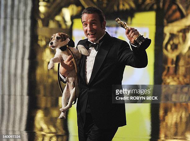 Best Actor winner Jean Dujardin walks off the stage with dog Uggie after "The Artist" won Best Movie onstage at the 84th Annual Academy Awards on...