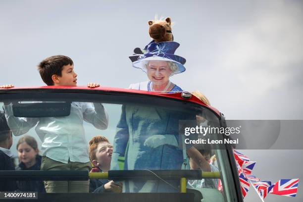 Cardboard cutout depicting Queen Elizabeth II is seen on the top of a decorated bus, as racegoers prepare for the days events, on June 04, 2022 in...