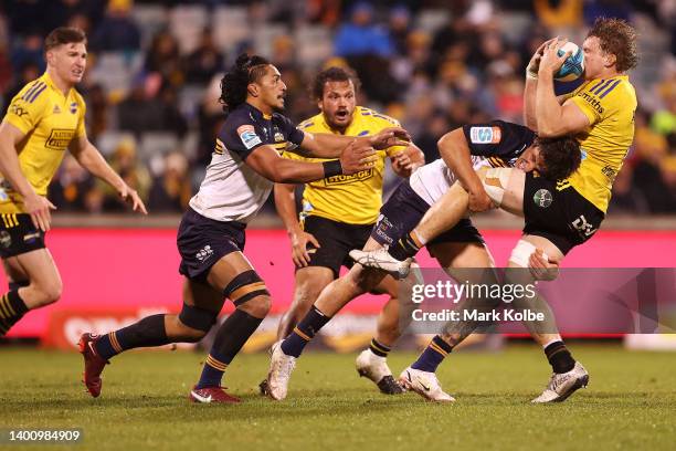 Ollie Sapsford of the Brumbies tackles Blake Gibson of the Hurricanes during the Super Rugby Pacific Quarter Final match between the ACT Brumbies and...