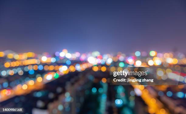 city buildings from a height overlooking the city panorama, buildings and roads - bokeh lights fotografías e imágenes de stock