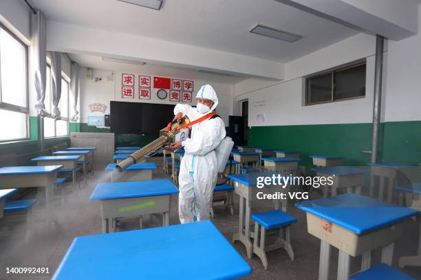 Volunteer disinfects an exam venue for China's national college entrance exam on June 4, 2022 in Pingliang, Gansu Province of China.