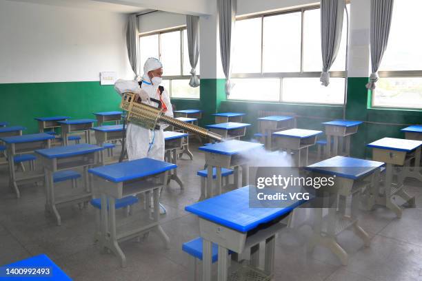 Volunteer disinfects an exam venue for China's national college entrance exam on June 4, 2022 in Pingliang, Gansu Province of China.