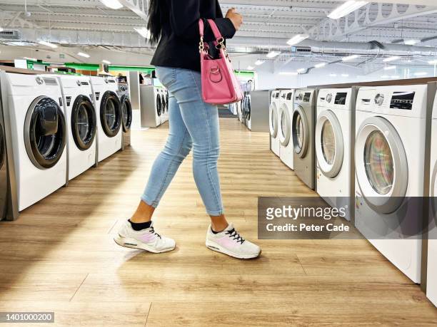 woman looking at washing machines - buying washing machine stock pictures, royalty-free photos & images