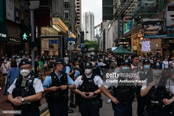 Police officers stand guards at Causeway Bay district near Victoria Park, the traditional site of the annual Tiananmen candlelight vigil, on June 04,...