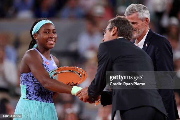 Coco Gauff of The United States shakes hands with Mats Wilander after being presented with the runners up trophy after losing against Iga Swiatek of...