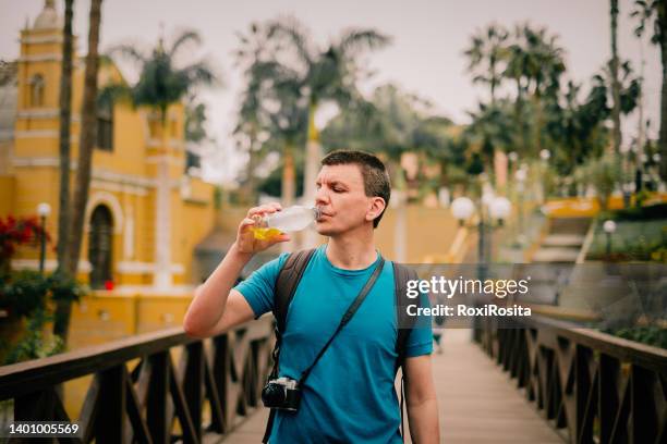 close-up of middle-aged man drinking a yellow drink - lima perú stock-fotos und bilder