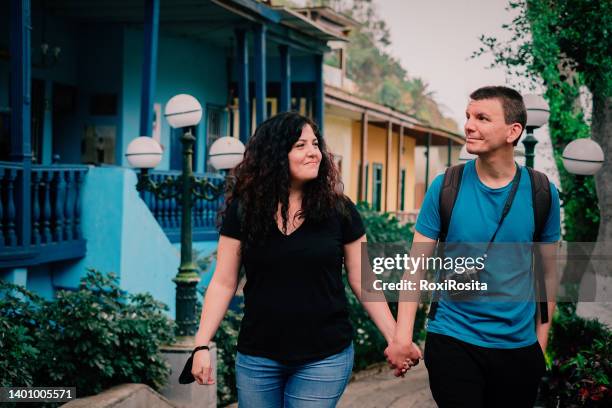 heterosexual couple happily walking hand in hand down a picturesque street in peru - lima perú stockfoto's en -beelden