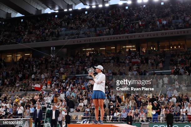 Iga Swiatek of Poland kisses the trophy after winning against Coco Gauff of The United States during the Women’s Singles final match on Day 14 of The...