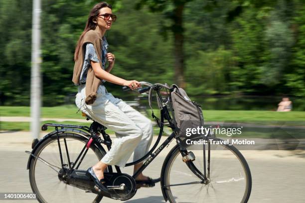 frauen radeln im stadtpark an einem sommertag, vondelpark, amsterdam - rugzak stock-fotos und bilder