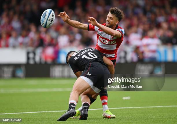 Adam Hastings of Gloucester Rugby offloads the ball under pressure from Manu Vunipola of Saracens during the Gallagher Premiership Rugby match...