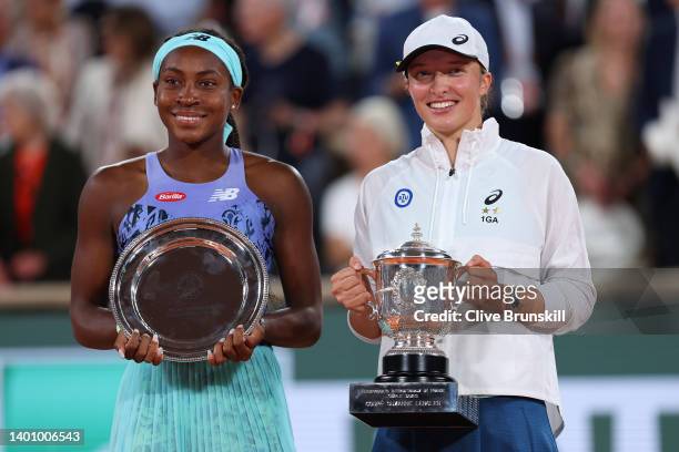 Iga Swiatek of Poland poses with the winners trophy as Coco Gauff of The United States poses with the runners up trophy after their Women’s Singles...