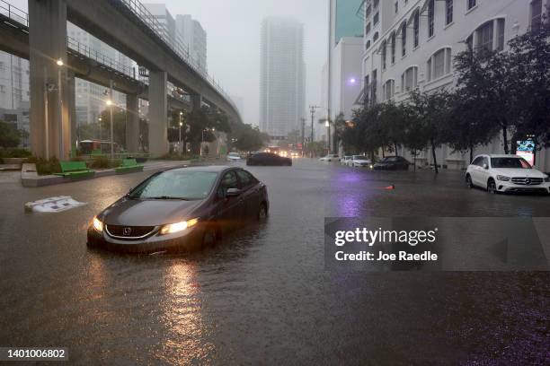 Cars sit in a flooded street caused by a deluge of rain from a tropical rain storm passing through the area on June 04, 2022 in Miami, Florida. The...