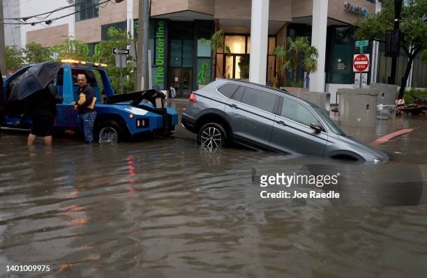 Vehicle is prepared to be towed after it died while being driven through a flooded street caused by a deluge of rain from a tropical rain storm...