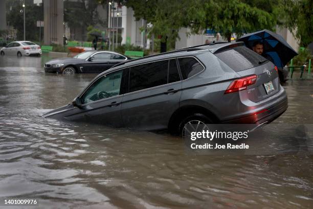 Vehicle is prepared to be towed after it died while being driven through a flooded street caused by a deluge of rain from a tropical rain storm...