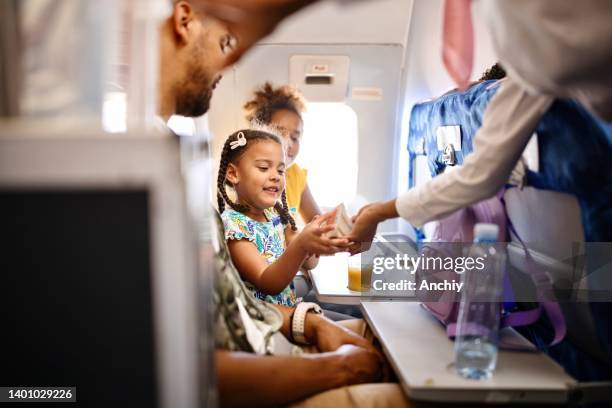 stewardesses serving food and drinks to family on the airplane during flight - crew 個照片及圖片檔