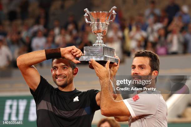 Jean-Julien Rojer of Netherlands and partner Marcelo Arevalo of El Salvador celebrate with the trophy after winning against Ivan Dodig of Croatia and...