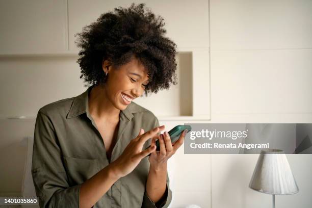 mulher negra fazendo compras online em casa - pessoa usando celular - fotografias e filmes do acervo