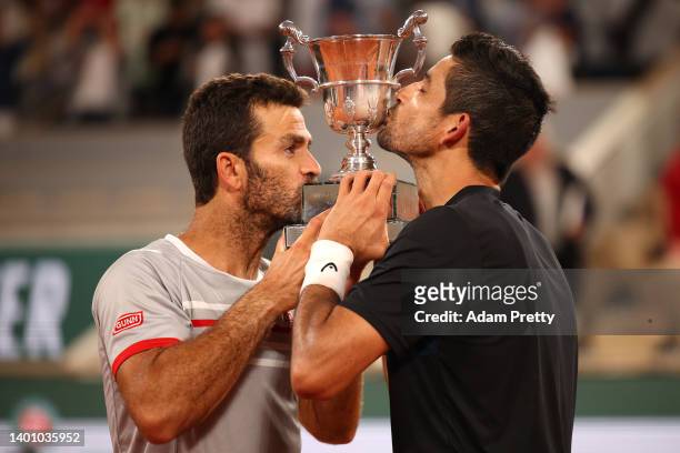 Jean-Julien Rojer of Netherlands and partner Marcelo Arevalo of El Salvador celebrate with the trophy after winning against Ivan Dodig of Croatia and...