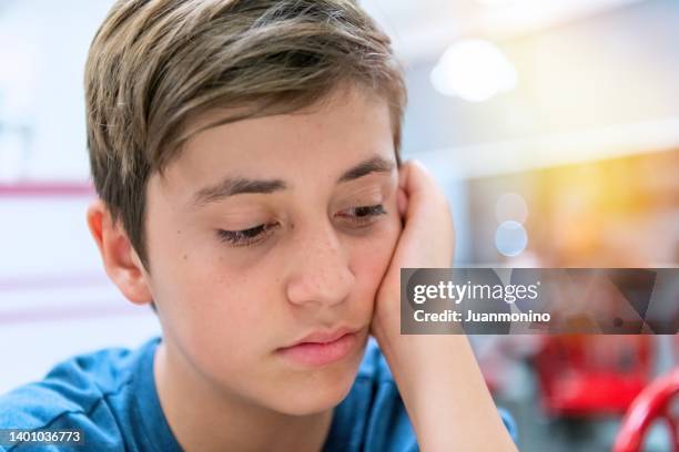 sad, pensive, worried, teenage boy looking down - autismus stock pictures, royalty-free photos & images
