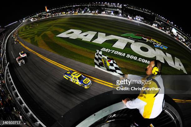 Matt Kenseth, driver of the Best Buy Ford, takes the checkered flag to win the NASCAR Sprint Cup Series Daytona 500 at Daytona International Speedway...