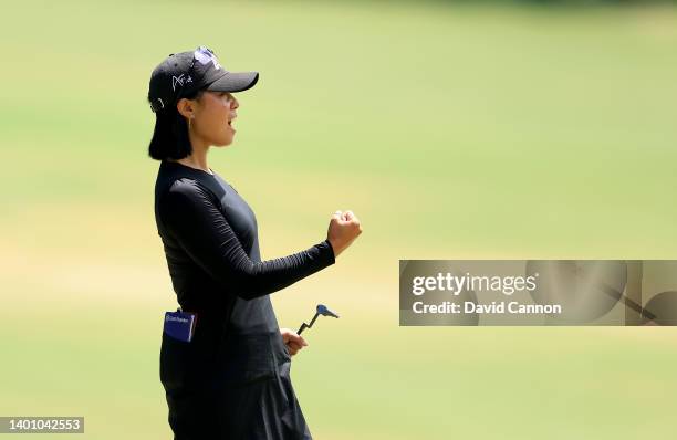 Danielle Kang of The United States signals encouragement to Lizette Salas who was teeing off on the first hole whilst Kang putted on the 18th hole...