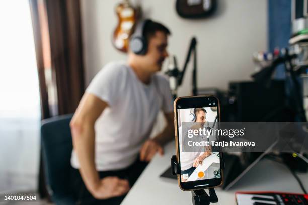 male podcaster making audio podcast from her home studio - livestreaming stock-fotos und bilder