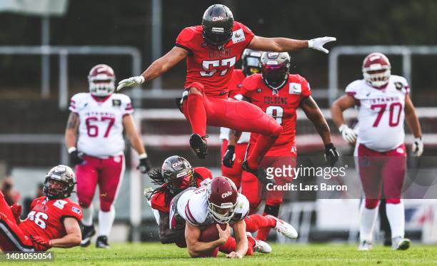 Flamur Simon of Cologne jumps over team mate Kalon Beverly and Jared Stegman of Istanbul during the European League of Football match between Cologne...