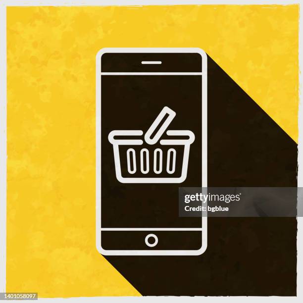 smartphone with shopping basket. icon with long shadow on textured yellow background - counter texture stock illustrations