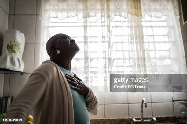 senior woman feeling pain at home - women being strangled stockfoto's en -beelden
