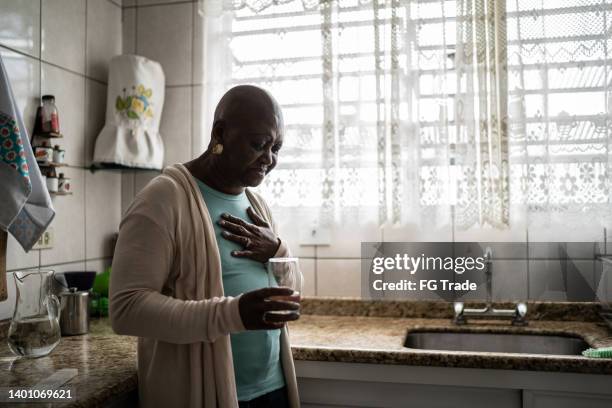 senior woman feeling pain at home - chest pain stock pictures, royalty-free photos & images