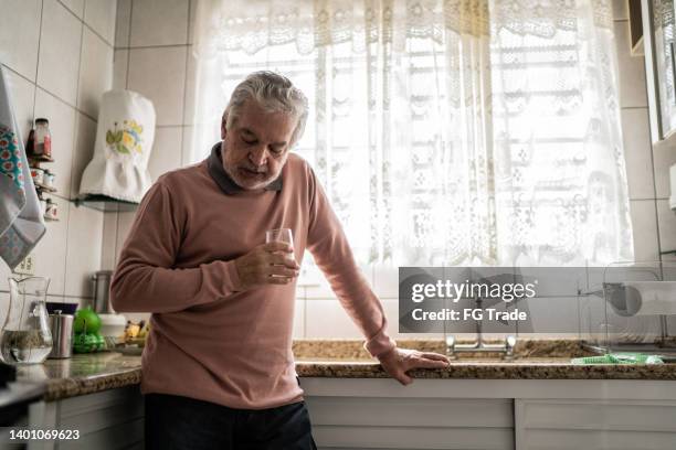 senior man feeling pain at home - tontura imagens e fotografias de stock