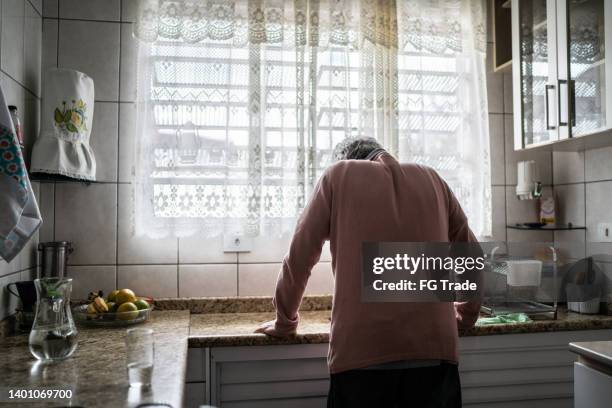 hombre mayor sintiendo dolor en casa - soledad fotografías e imágenes de stock