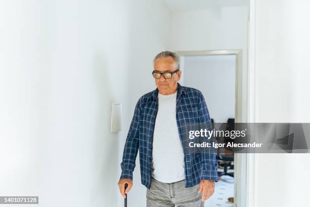 anciano caminando en casa con bastón - despacito fotografías e imágenes de stock