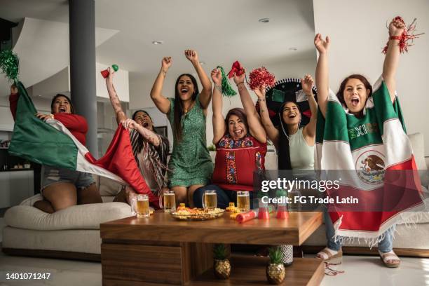 friends celebrating mexican soccer team goal at home - mexican ethnicity stockfoto's en -beelden