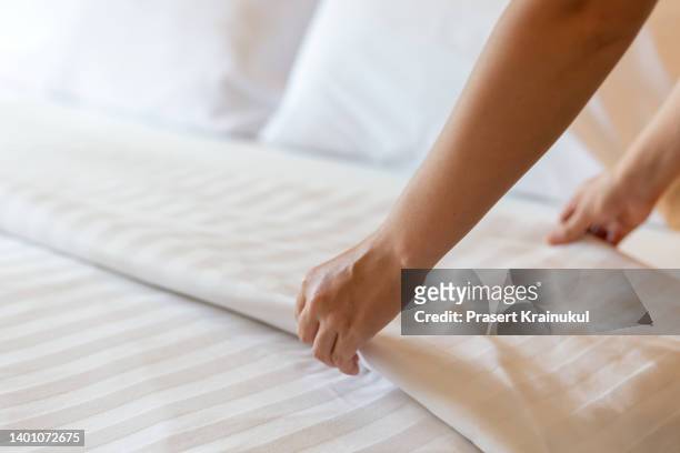 housekeeper set of white bed linens in bedroom. hotel concept - cleaning lady - fotografias e filmes do acervo