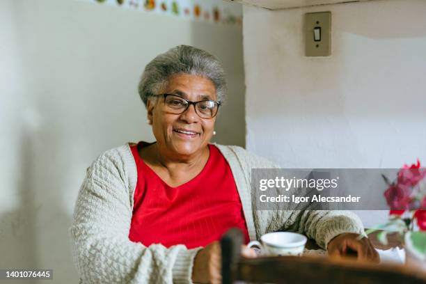 smiling elderly woman drinking coffee at home - documentary stock pictures, royalty-free photos & images