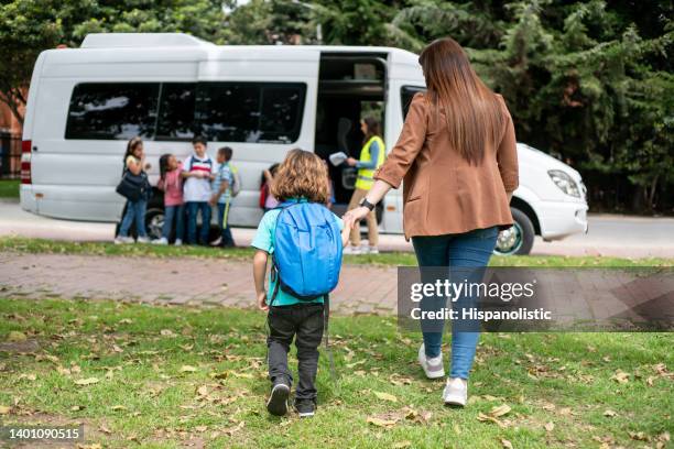 mother taking her son to the school bus stop - shuttle bus stock pictures, royalty-free photos & images