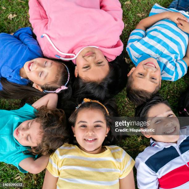 happy group of kids lying on the floor and smiling - laying park stock pictures, royalty-free photos & images
