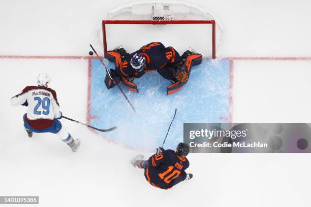 Mike Smith of the Edmonton Oilers makes a save against Nathan MacKinnon of the Colorado Avalanche as Derek Ryan of the Edmonton Oilers looks on in...